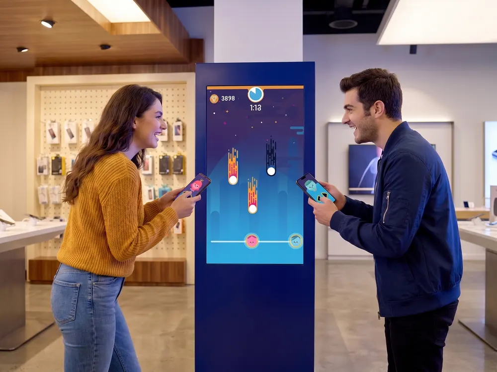 Two customers in a phone store play a two-player game on a large in-store screen, each using their own phone as the controller.